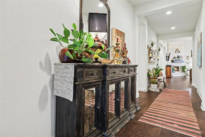 Rich hardwood flooring guides the eye through this welcoming entry hall toward the living spaces.