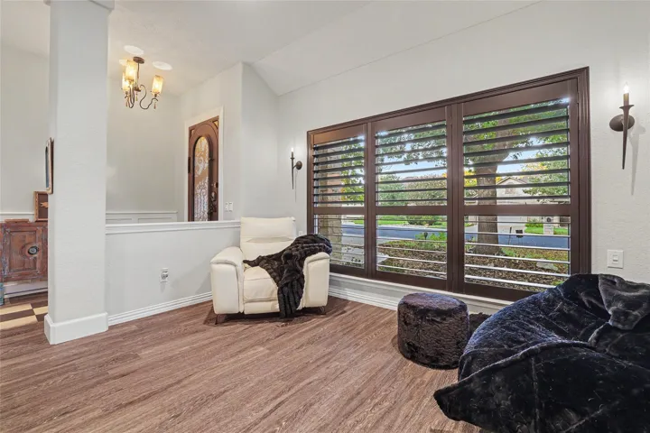 The Plantation Shutters in the living room appear brown in this photo, but they are actually a rich black .  Notice the lighting sconces on either side.  This window was completely replaced...