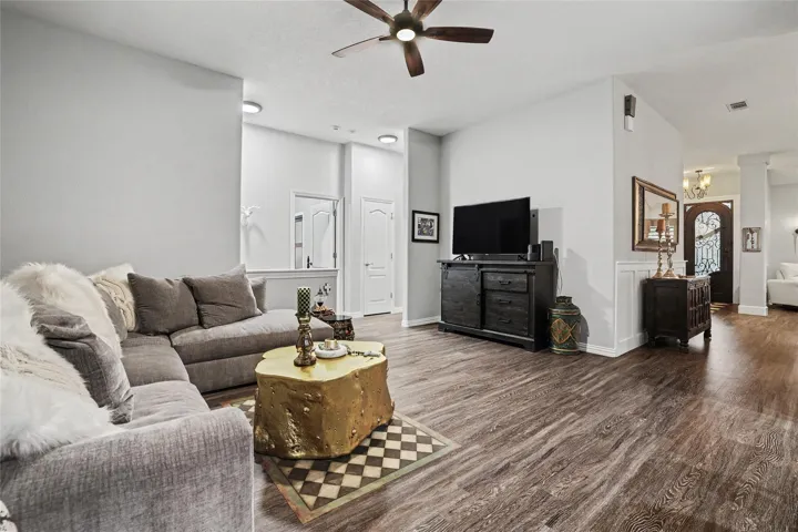 This view of the family room reaches out to the foyer & living room on the right, on the left, a wide hallway opening to the bedrooms and utility room...and then an entry to the garage...
