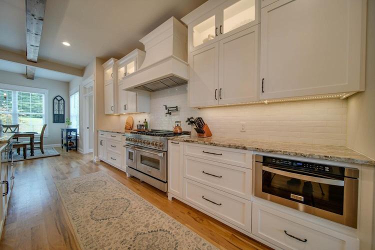 Floor to ceiling custom cabinets feature lighting in the top glass doors