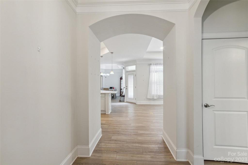 Large entryway foyer with arched doorways leading to the open kitchen and living room.