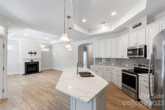 Gorgeous kitchen w/ quartz countertops open to living room and dining room