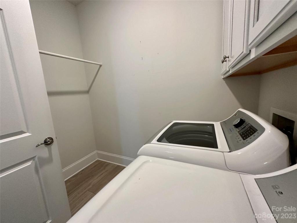 Laundry Room with overhead cabinets and additional storage space.