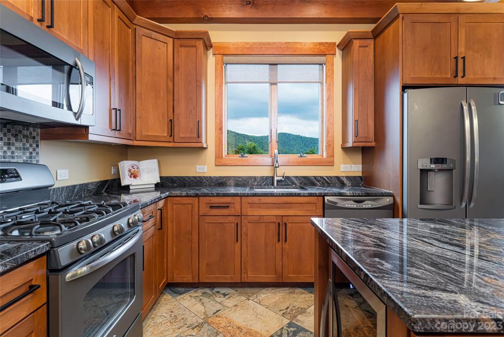 Tastefully appointed kitchen with beautiful, rich granite and appliances that blend with the natural slate floors