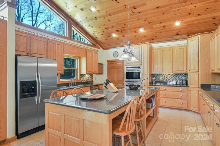 This gourmet kitchen has an oversized bar with sink.
