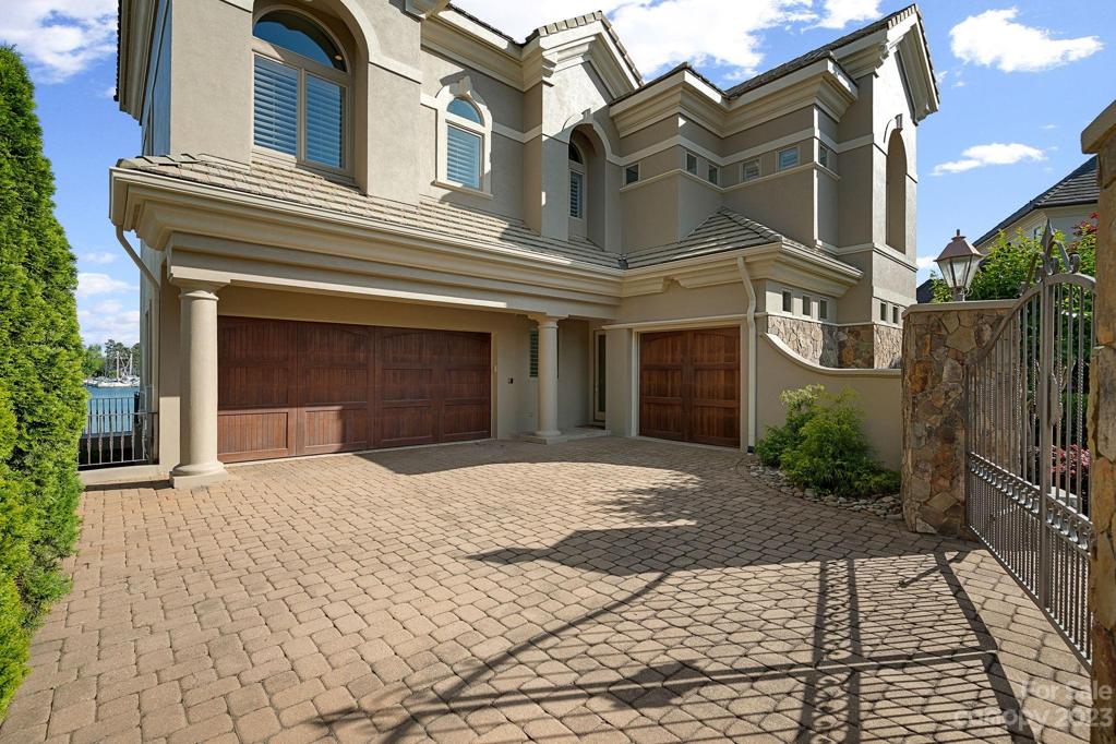 Gated entry to dual garage with storage, single car garage equipped with custom cabinets