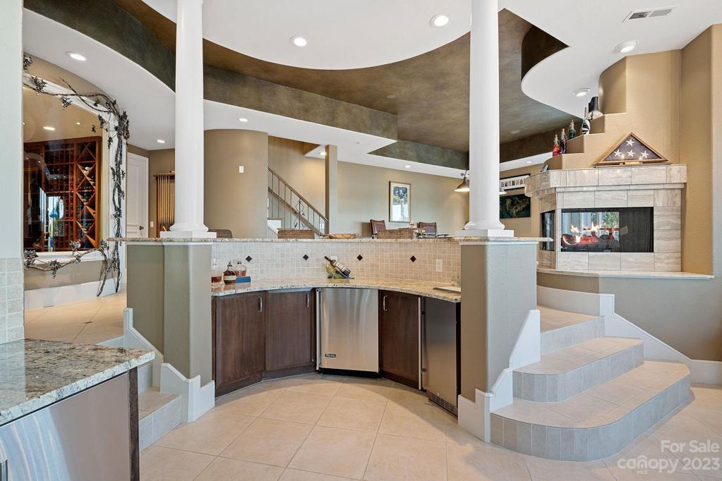 Wine room to the left is accentuated with custom iron work created by local artist, Ben Parrish. Lower level kitchenette features Viking dishwasher, mini fridge, Viking Professional microwave/convection oven, icemaker and Kegerator