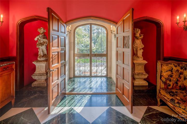 Graced by the glowing wall sconces, the original solid walnut doors heighten the sense of quality historical preservation.