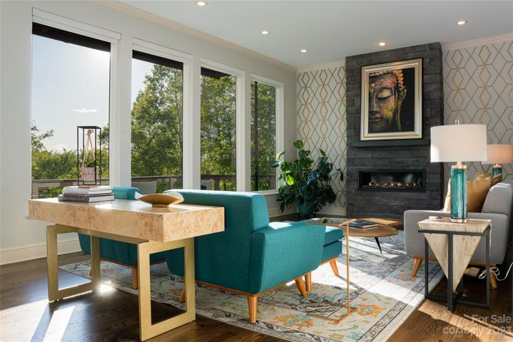The open concept living room is still cozy and inviting with rich wall treatments and beautiful views...
