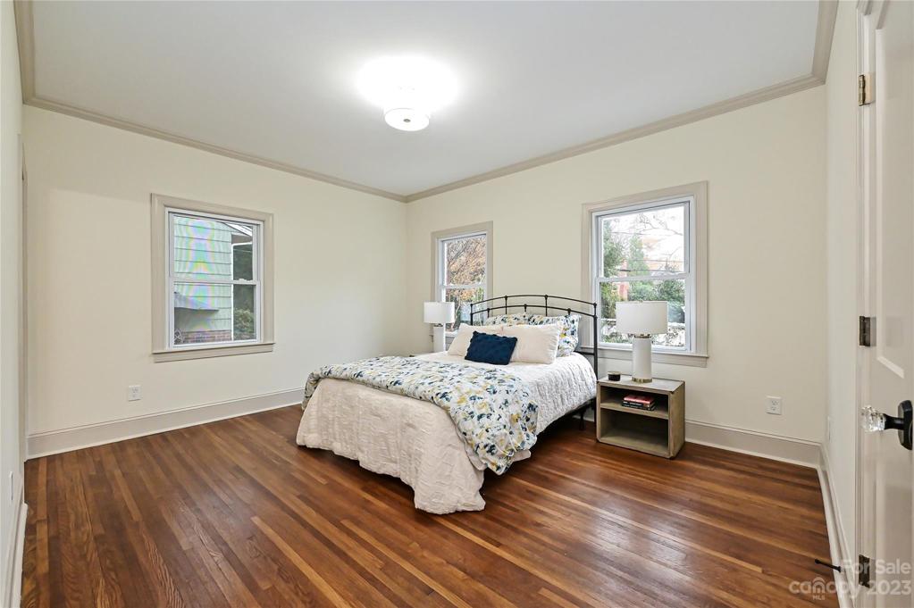 Spacious primary bedroom also has original hardwoods and secondary storage closet