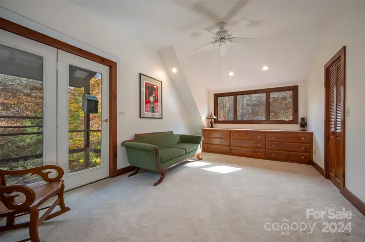Primary Bedroom. Door to the left leads to a covered balcony. Built-ins under the window and walk-in closet to the right.