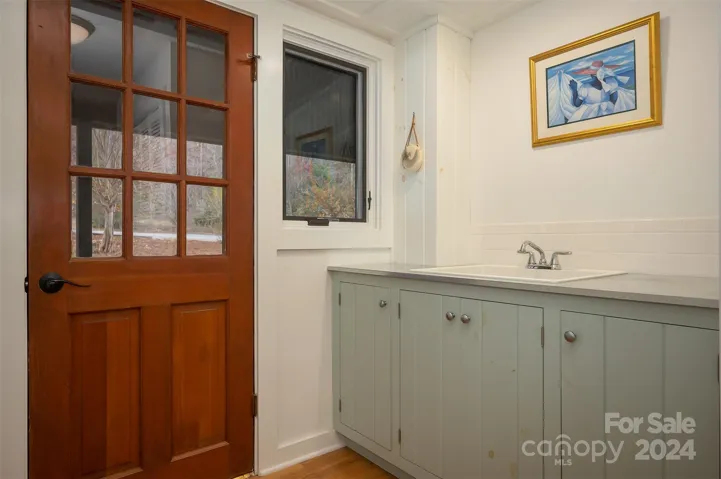 Laundry sink and storage. Door is the entrance from the front porch.