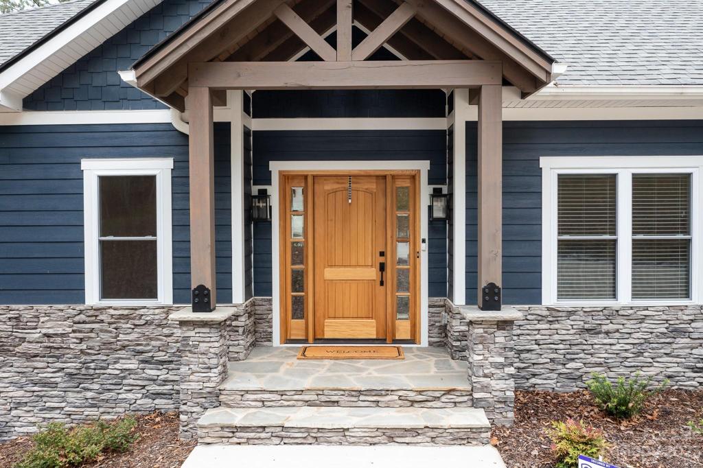 Craftsman style entry with beams and wood door