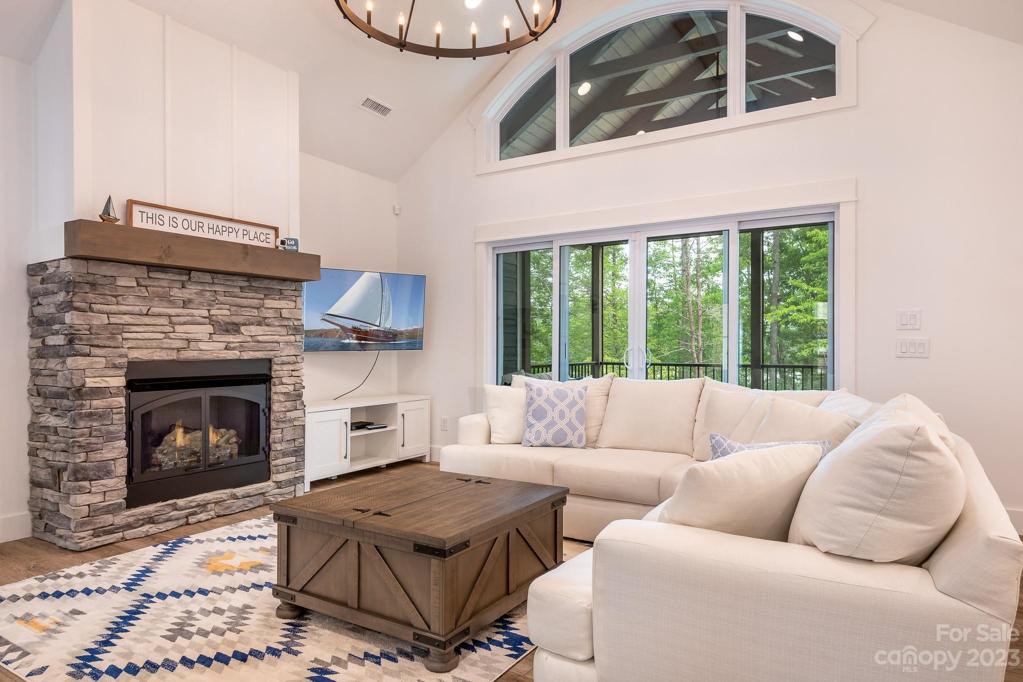 Living room with stone fireplace with gas logs