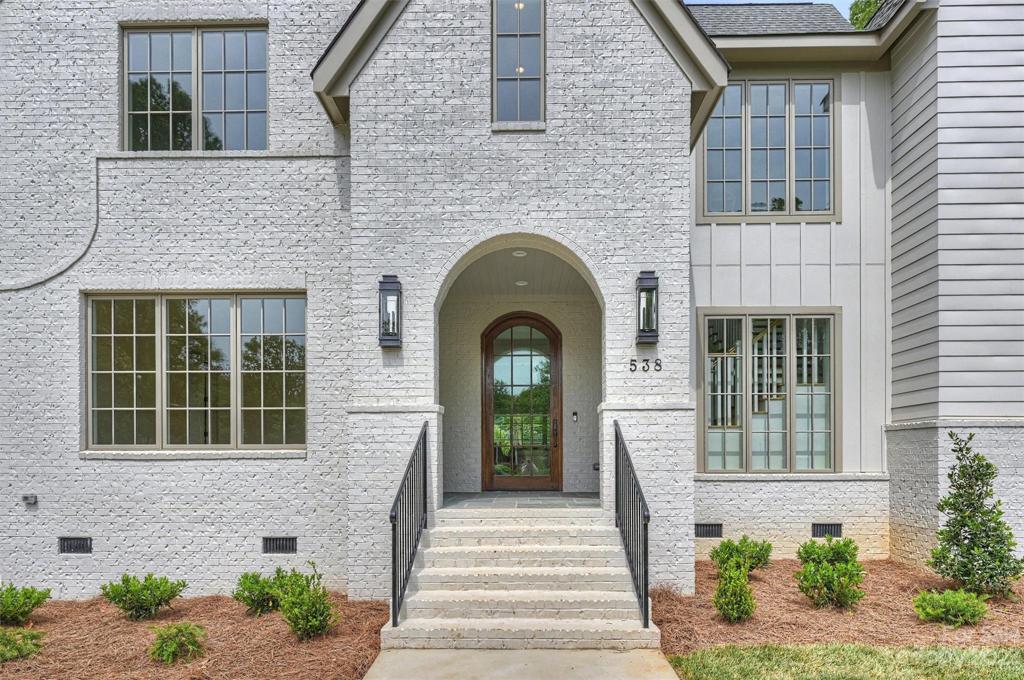 Prepare to be impressed as you step through the magnificent, handcrafted 9’ arched white oak front door, graced by a picturesque brick portico.