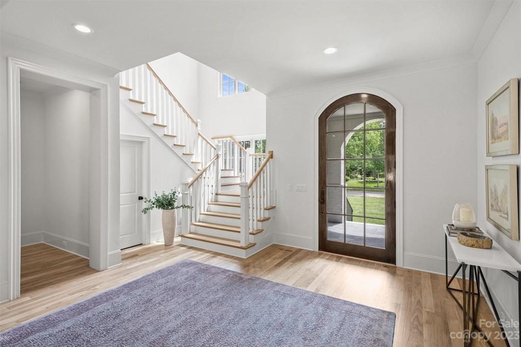 The 2-story foyer is adorned with an open staircase and large array of windows, bathing the transitional style home in an abundance of natural light.