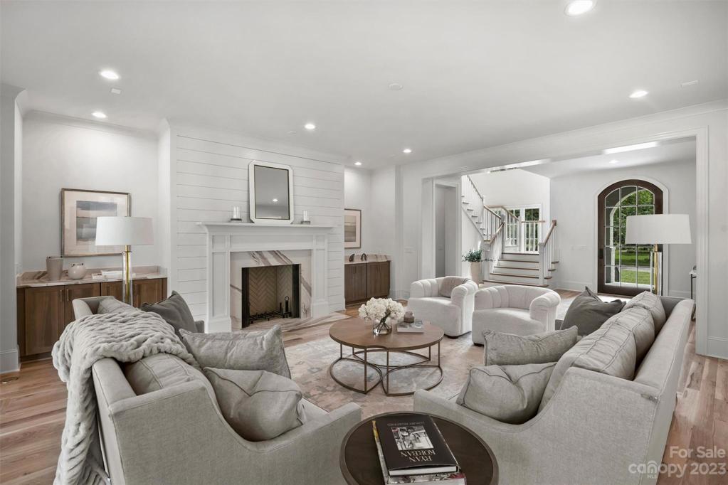 The inviting living room showcases custom corner built-ins with quartz countertops and a cozy fireplace with shiplap surround.