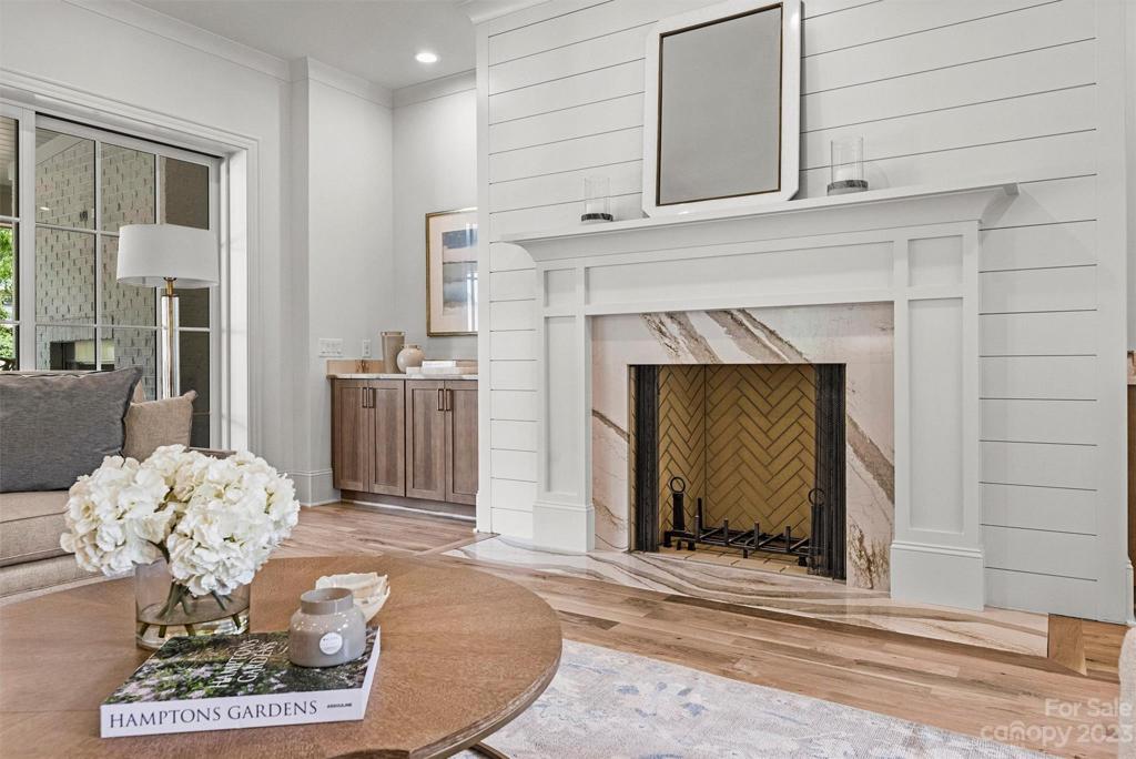 Beautiful wood burning fireplace with gas starter is surrounded by a quartz and shiplap surround.