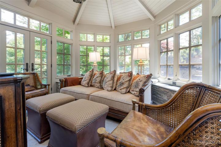 This sunroom invites you to either enjoy receiving your vitamin D through those windows or you may choose to go out those French doors for your direct dose of sunshine. The custom ceiling is a handmade work of beauty.