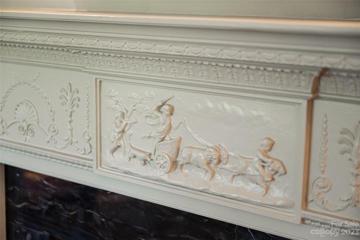 The original hand carved fireplace mantel highlights the talented artisans who created uniquely detailed works of art