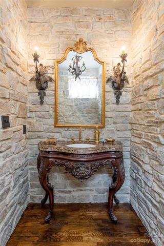 Back inside, your guests' powder room continues the storybook enchantment of your legacy home. The wall sconces were designed by Bree Iron Work.