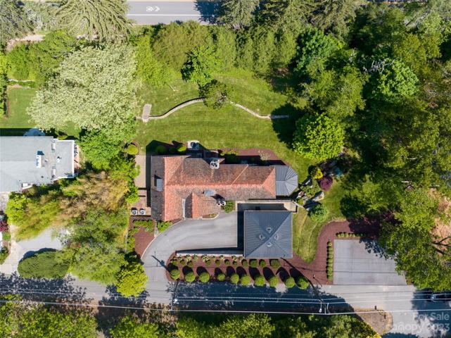 A bird's eye perspective shows you the walkable sidewalks and bike lanes in this Grove Park neighborhood, the lush landscaping surrounding your home, the 2-car garage/driveway/additional parking pad on the right, as well as the copper standing seam roofs atop the garage and the sunroom.