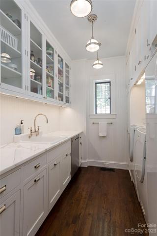 The perfect accent to your kitchen: a butler's pantry extraordinaire with custom handmade cabinetry! It is accompanied by a top-of-the-line Bosch washer & dryer for your laundry.