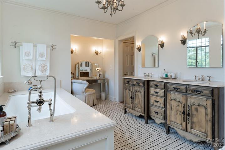 ...and exquisite wall sconces, an antique chandelier, gorgeous tile floors, a boutique dressing table nook, and an incredibly stunning bathroom vanity.