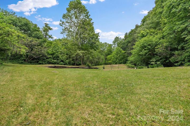 Cleared area with pond and garden in the distance