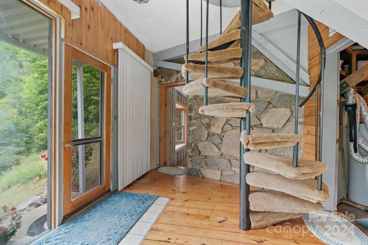 Spiral staircase allows access from the interior.  Notice the stone accent wall and large windows and wood floors