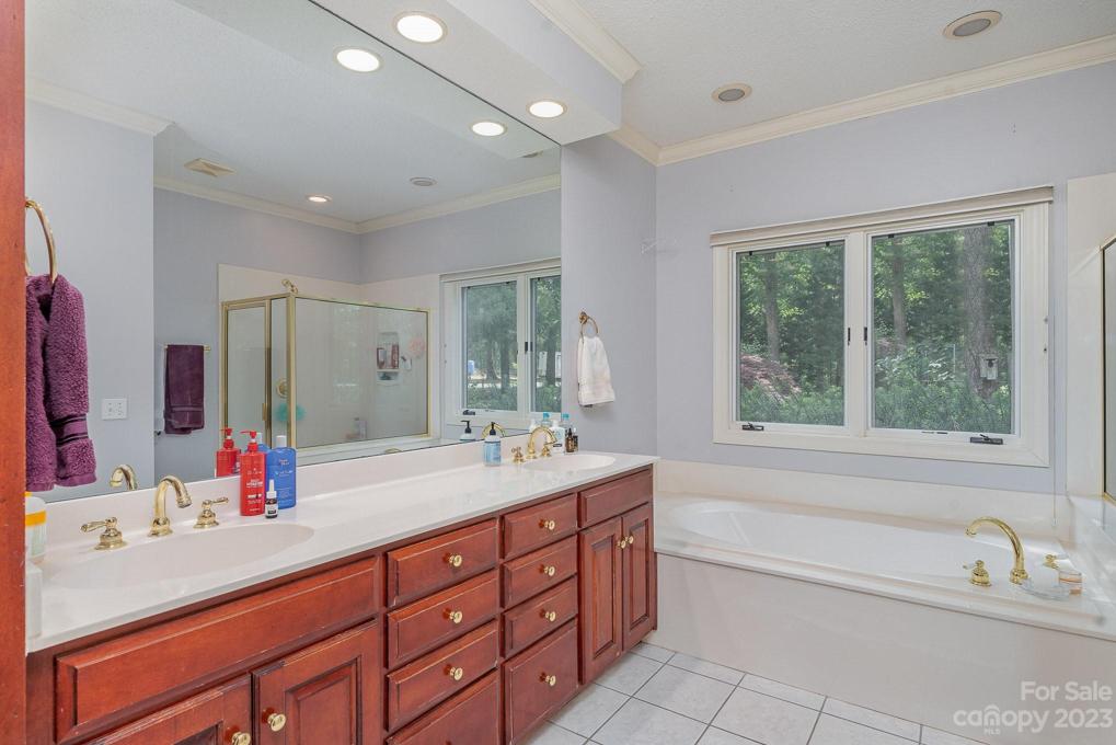 Primary bathroom with dual vanity, tub and stand-up shower
