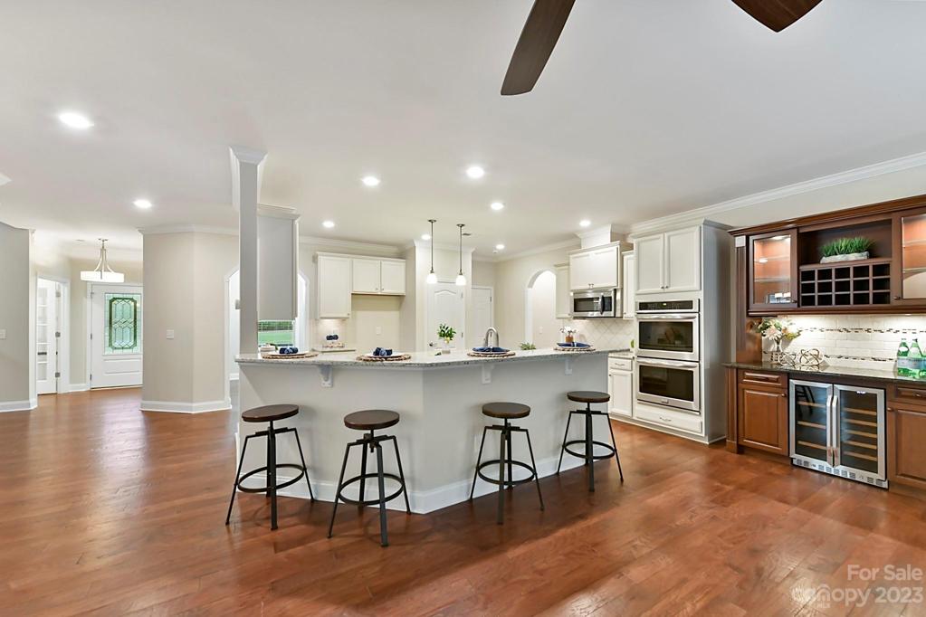 Kitchen Counter Overhang ideal for serving or Quick Meals. Built-in Bar Cabinet with Beverage Refrigerator and Lighted Cabinets