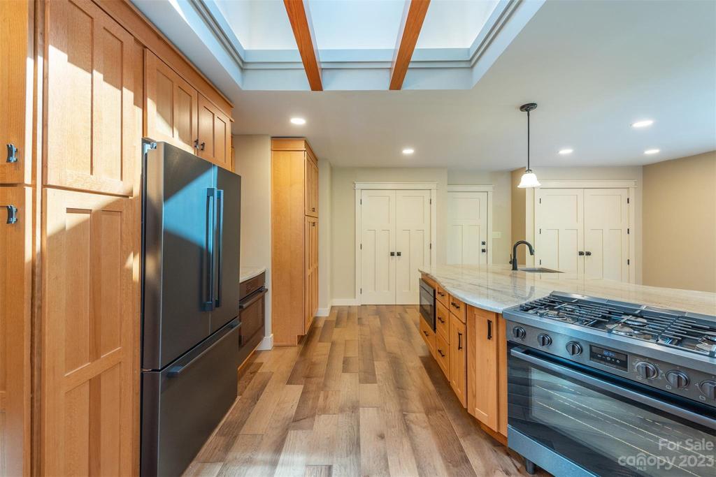 Plentiful cabinet space, here you can see the pantry cabinetry at the far end, purposefully not too deep so that everything can be organized. The microwave is under the counter on the right and the second oven is under the counter on the left.