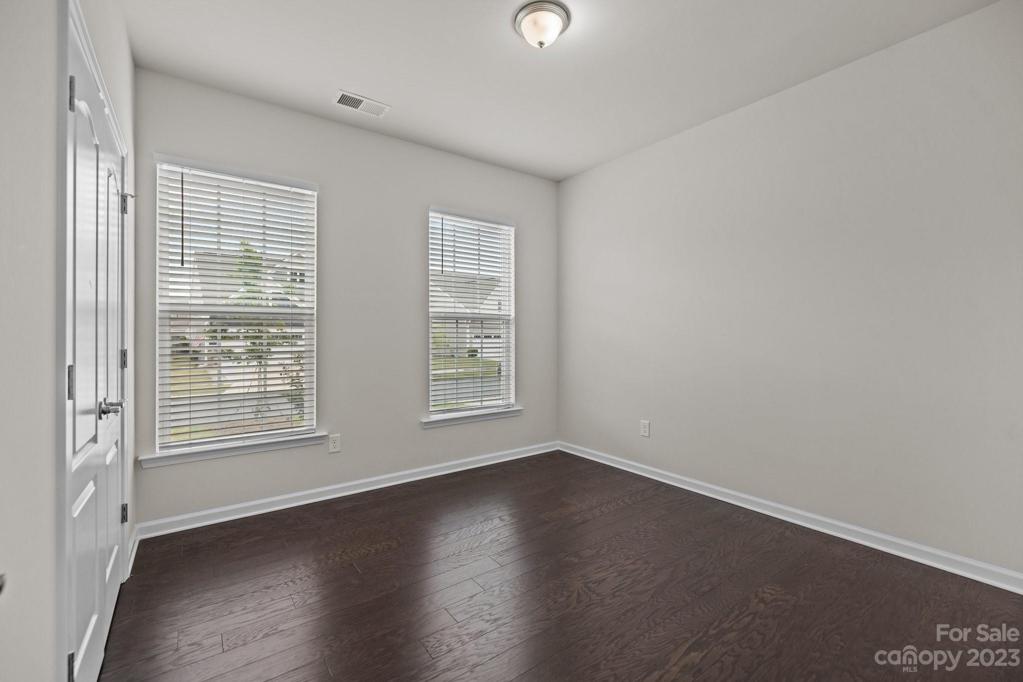 Second bedroom with wood floors and plenty of lighting.