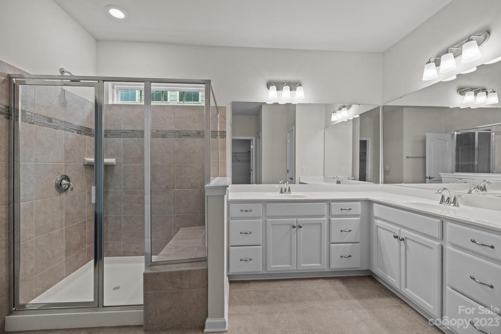 Primary bath with double vanity and bench seating in the shower