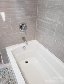 Tiled deep soaking tub with shower hall bathroom