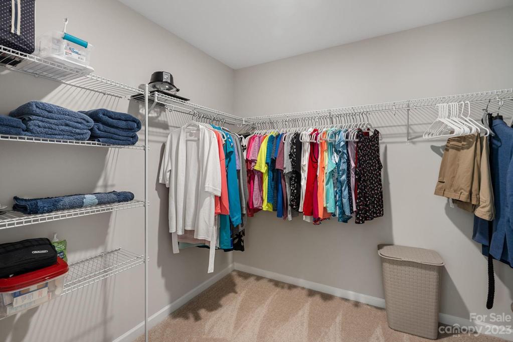 Huge walk in closet with shelving in primary.
