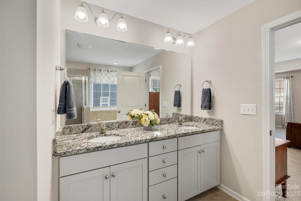 Dual sink vanity with granite in the primary bath.