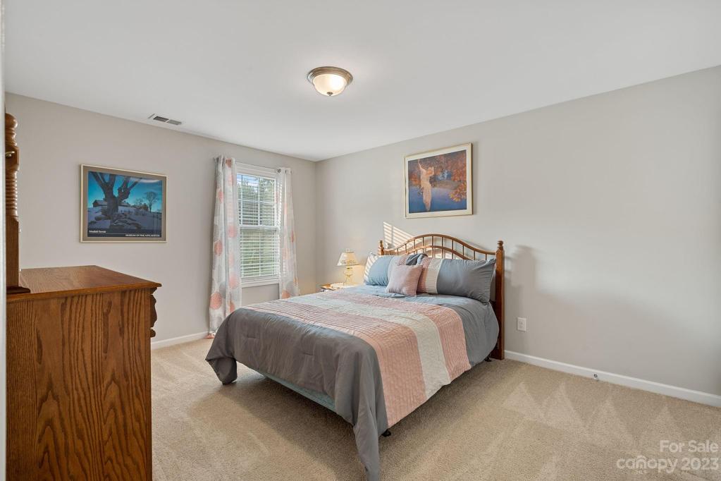 Spacious guest bedroom w/ walk-in closet overlooking the lovely backyard.