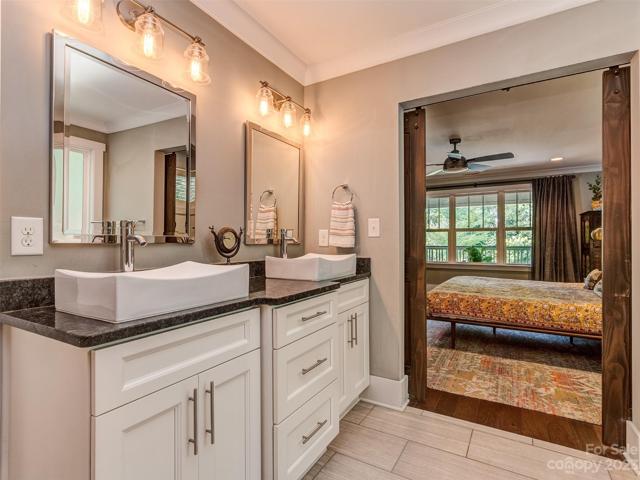 Barn Doors Open to your Primary Bath with Custom Dual Vanities, Tile Flooring, Custom Walk-In Shower, Soaking Tub and Lare Walk-in Closet.