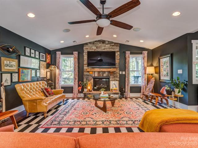 Great Room with vaulted ceiling, gas log fireplace, recessed lights, built-in speakers, & hardwood floors.