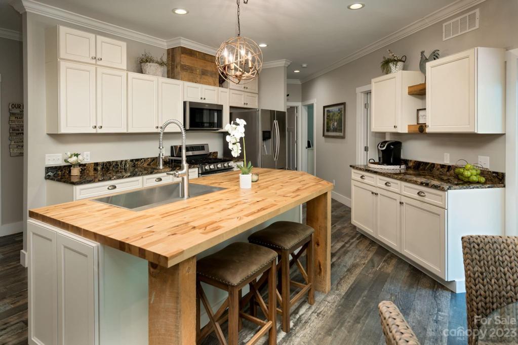 The chef’s kitchen is open to the living room and offers lovely granite countertops, oversized chopping block island with smart storage and extra seating, on-demand hot water, stainless steel appliances including 5-burner gas stove, breakfast nook and a spacious pantry storage.