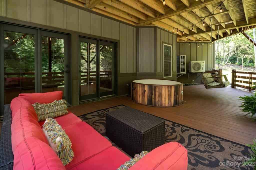 Adjoining covered deck on lower level with hot tub