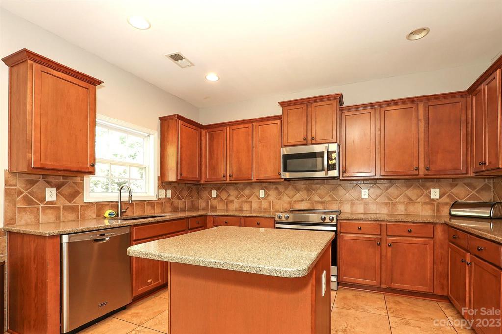 Gourmet Kitchen, granite countertops, w/Island, Custom Backsplash,SS Appliances, Butlers Pantry.