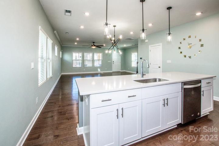 Beautiful white cabinets, pendant lights make it a bright work area