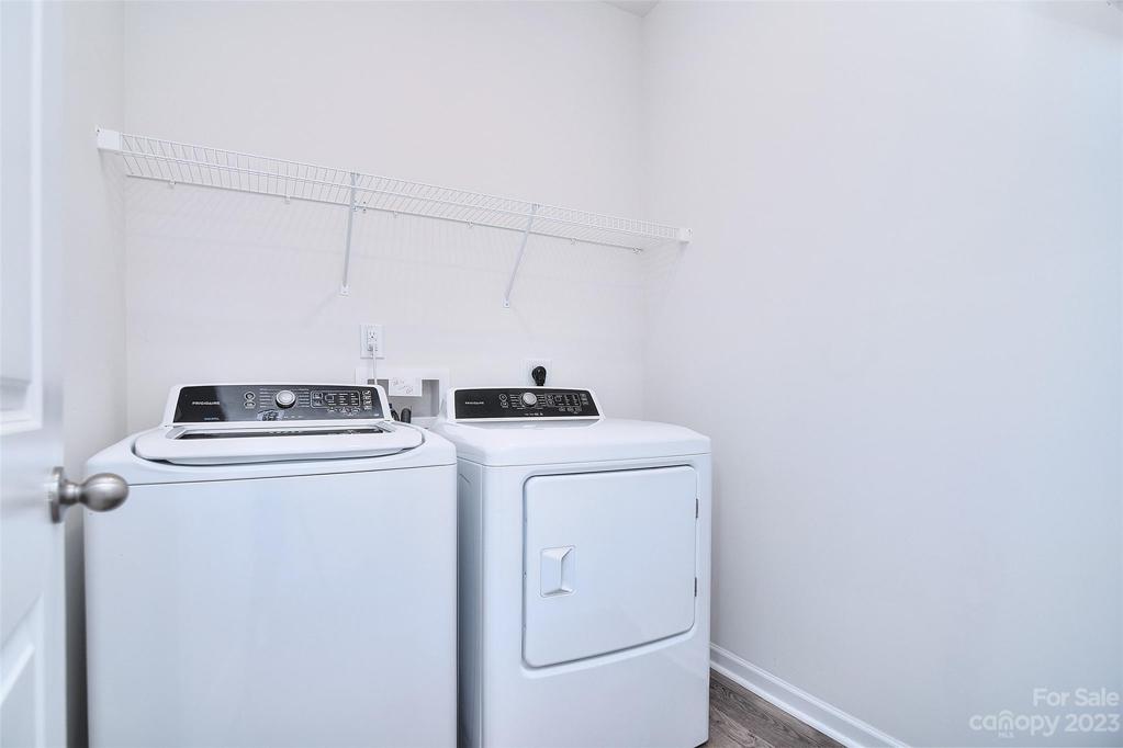 Laundry room has shelving for additional storage