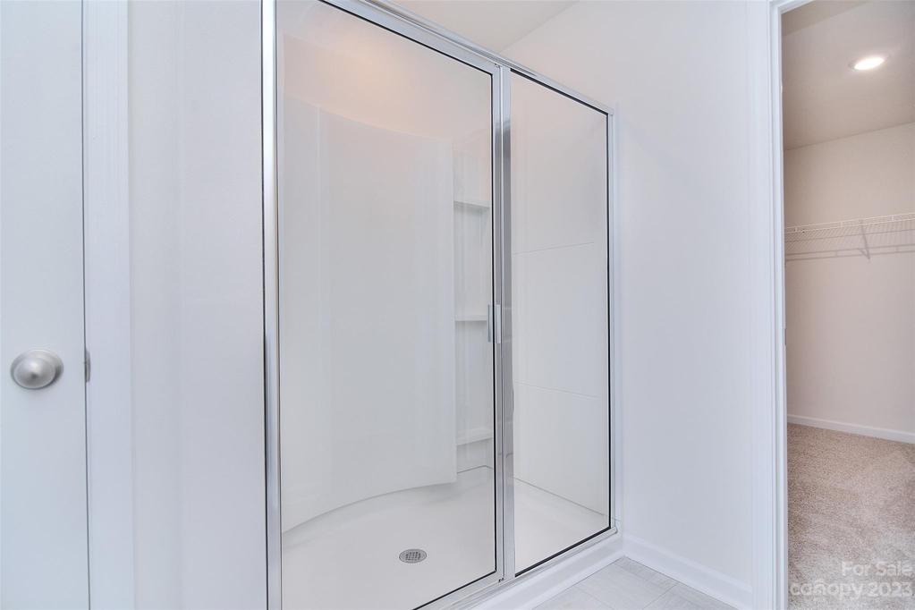 Large shower located in primary bedroom
