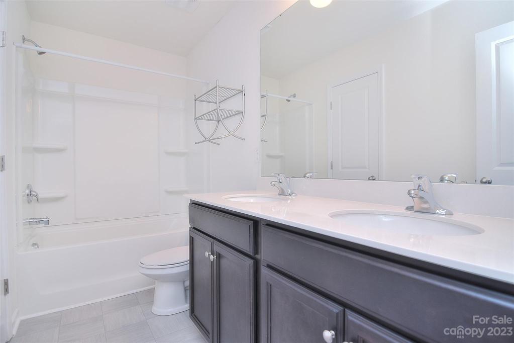 Guest bathroom on second floor also includes dual vanities and a shower/tub combo