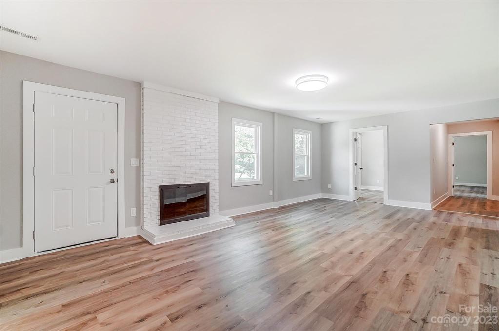 The front door welcomes you to this spacious living room with a fireplace.
