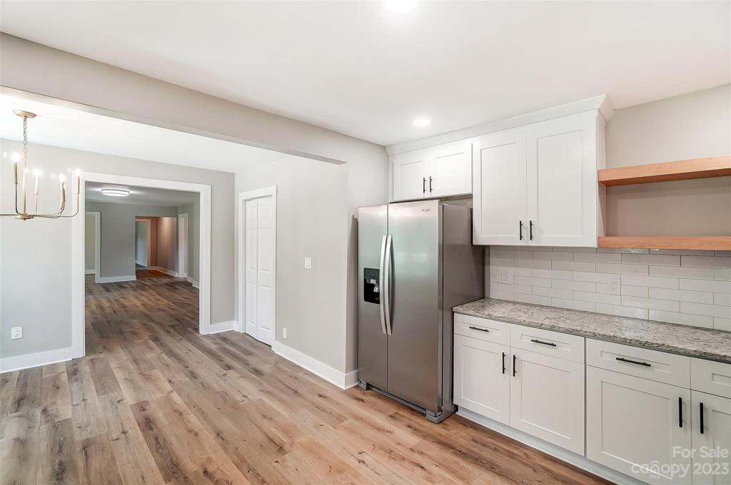 Wood shelves bring a warm touch to this modern cool kitchen.